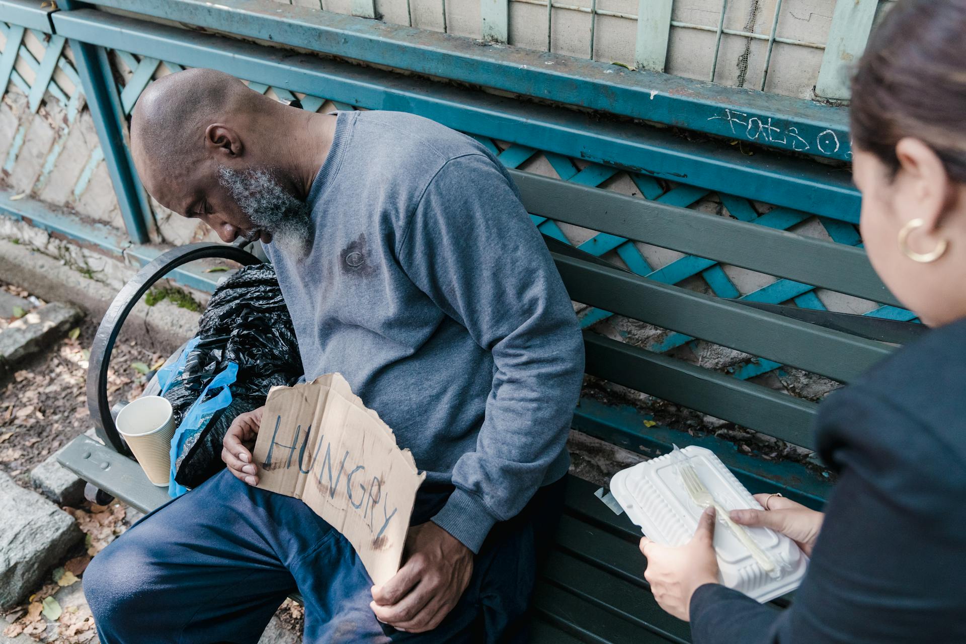 Man with "Hungry" sign receiving food